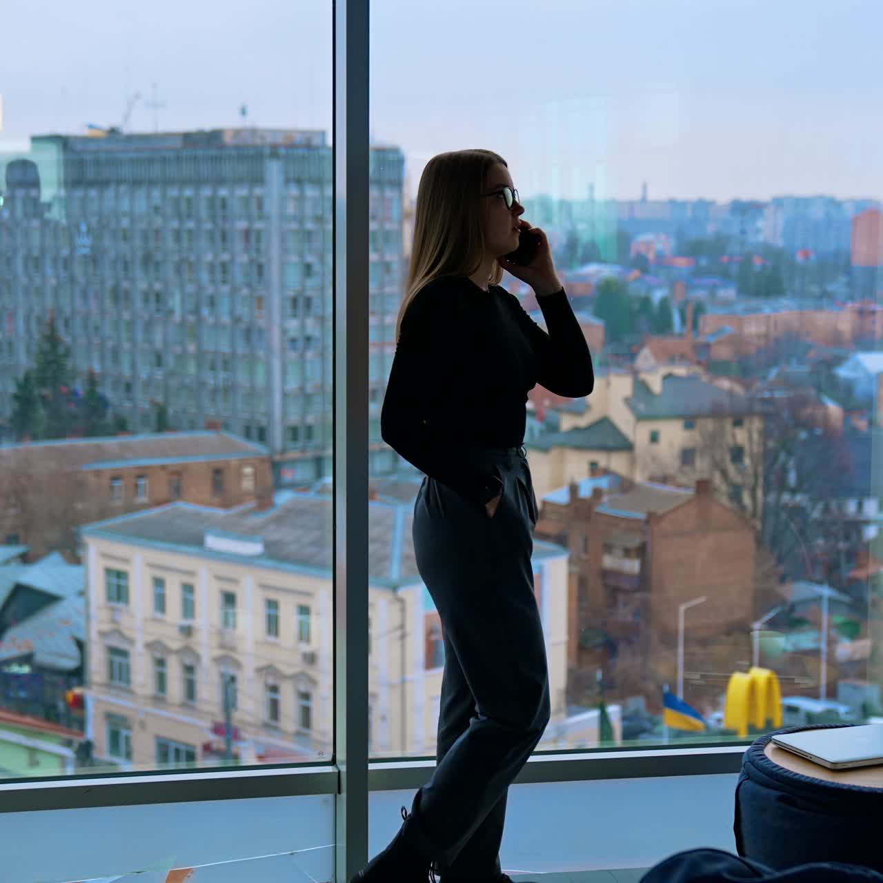 Attractive businesswoman in eyeglasses talking on cellphone