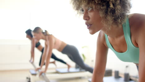 tres mujeres practicando yoga en un estudio brillante