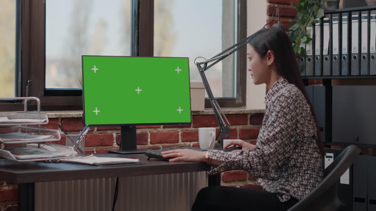Person using computer with green screen in business office