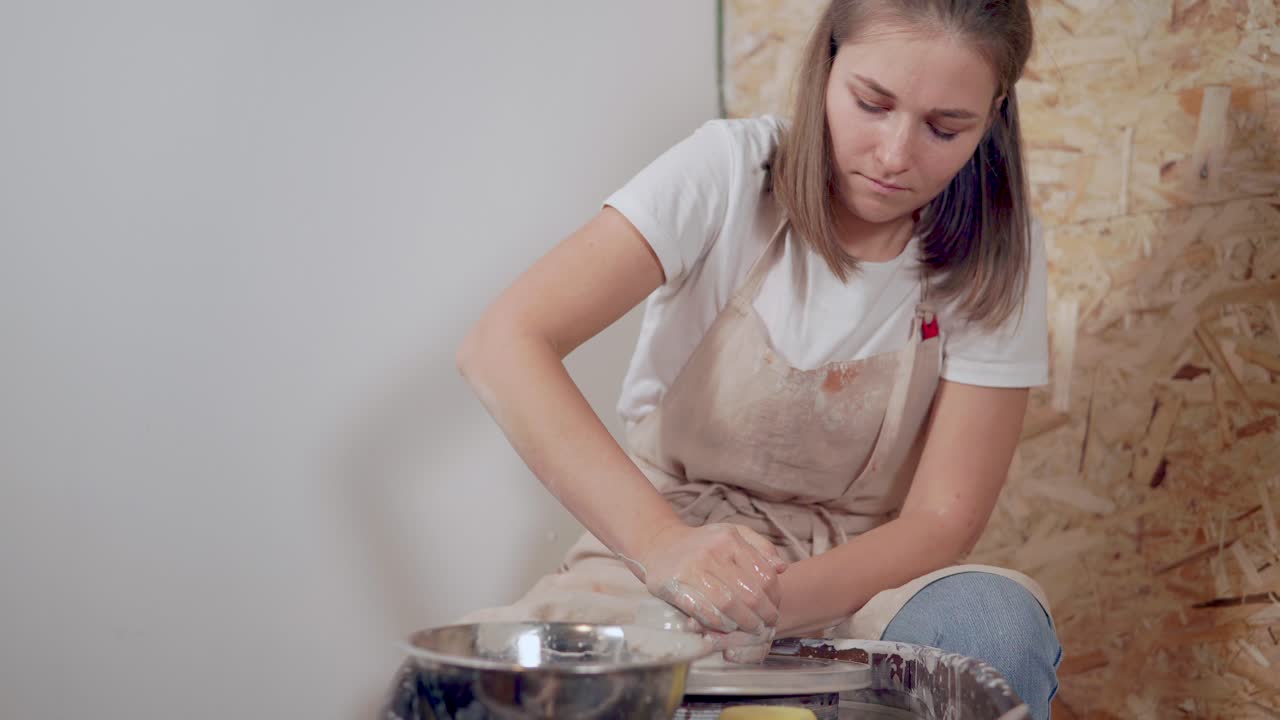 mujer trabajando con arcilla en una rueda de cerámica