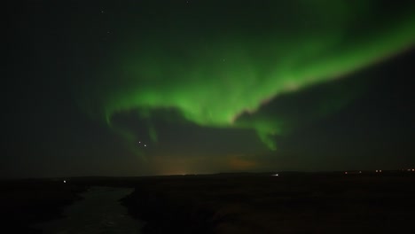 Panorama-shot-of-green-colored-Northern-Lights-in-motion-against-dark-sky-above-Iceland-Island