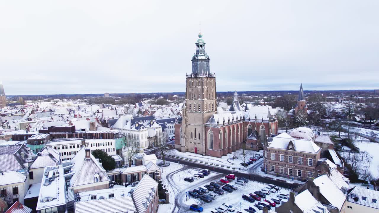 Paesaggio invernale fiabesco pittoresco, Zutphen, città olandese anseatica medievale con torri, nei Paesi Bassi, coperta di neve, avvicinamento aereo attraverso alberi spogli invernali