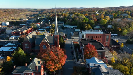 aerial establishing shot of town in usa during autumn fall foliage