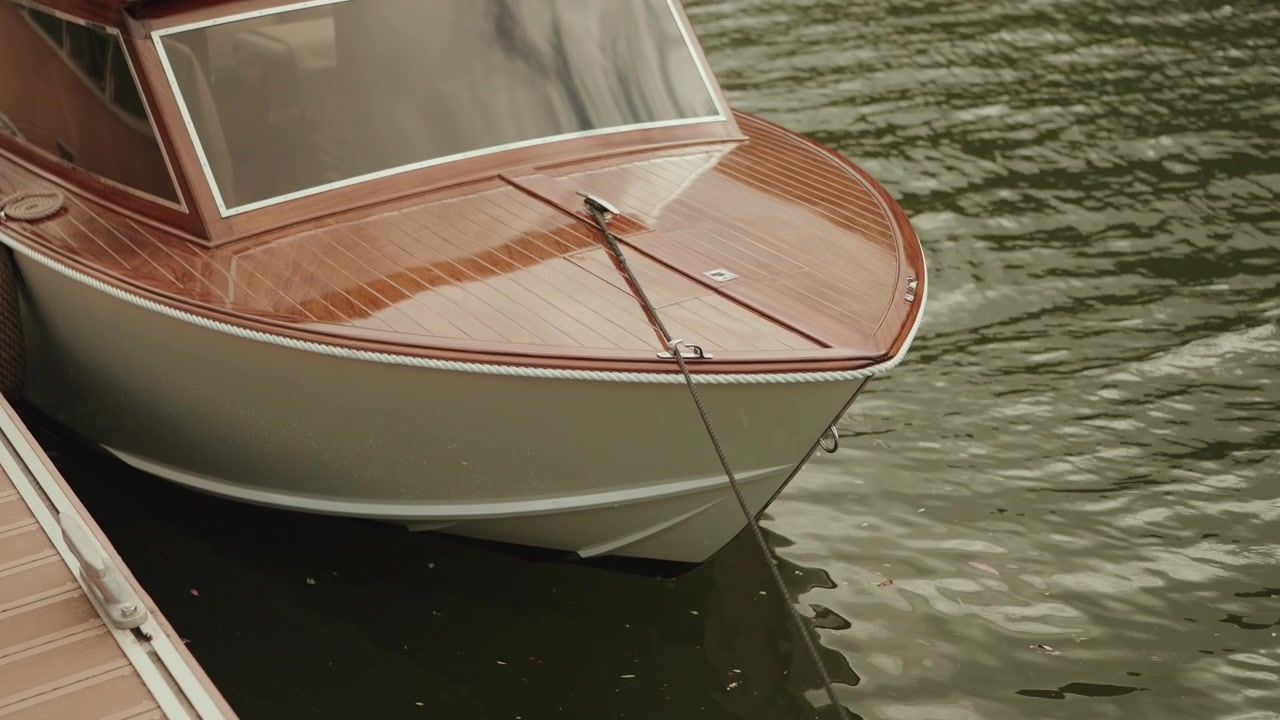 Motoscafo di lusso in legno ormeggiato al molo sul tranquillo fiume Douro con leggere increspature.