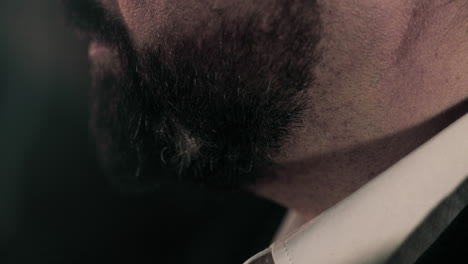 vista lateral de cerca de un hombre de negocios caucásico con una espesa barba negra de traje