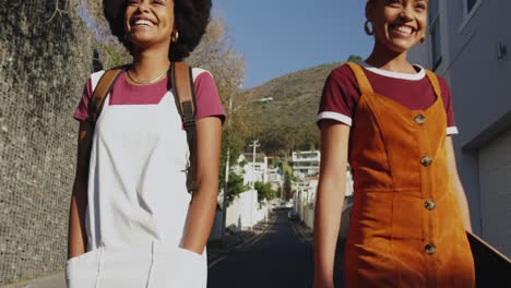 dos mujeres de raza mixta caminando por la calle