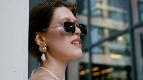 vista de cerca de una mujer elegante con gafas de sol y pendientes