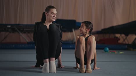 young gymnast training with coach in gym