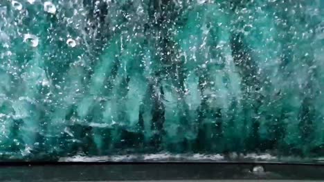 el auto que pasa por el lavado de autos y el parabrisas está lleno de agua