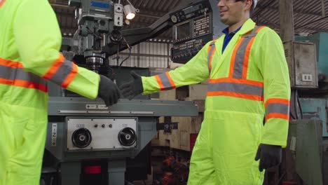 factory workers handshake with team member in the factory