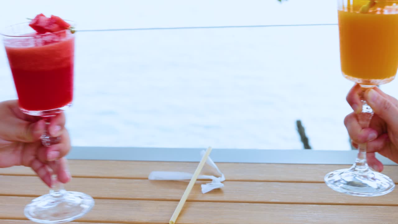 dos personas haciendo sonar vasos de jugo de fruta