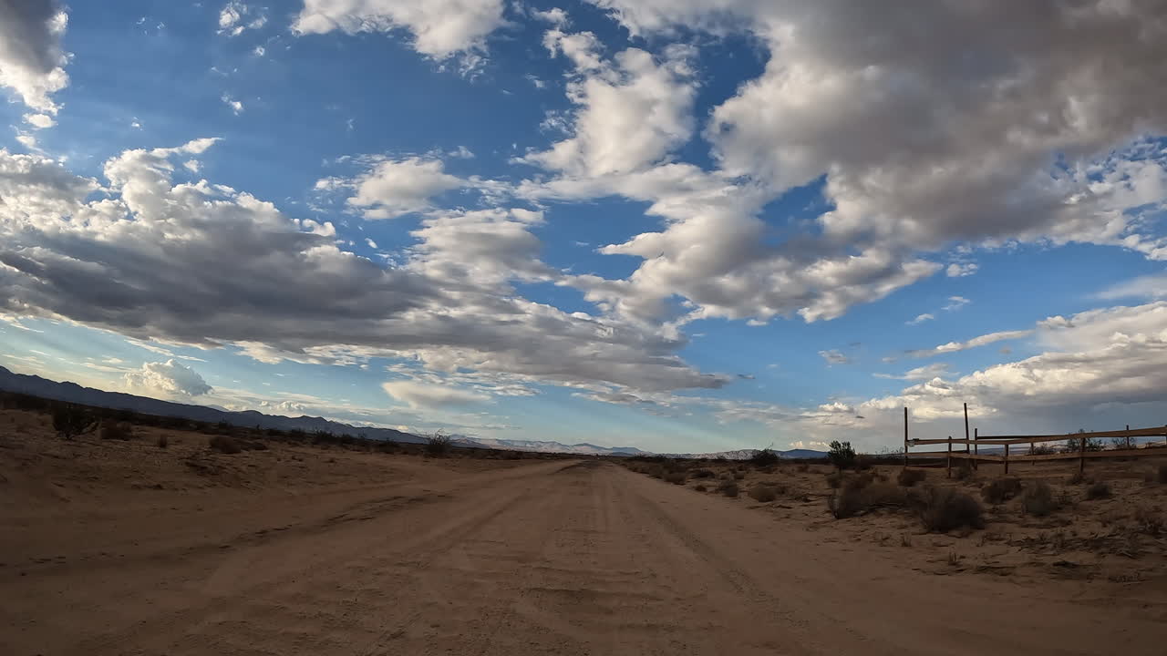 Guidando lungo una strada desolata del Deserto del Mojave verso un sentiero sterrato - hyper lapse di essersi persi nella natura selvaggia