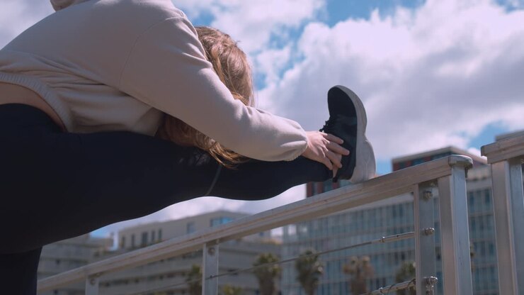 Static low angle shot of woman stretching legs outdoors