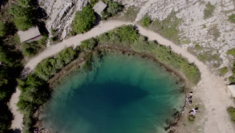 Video-Con-Un-Dron-De-Una-Grúa-De-Avión-Ascendiendo-A-Una-Vista-De-Pájaro-Sobre-El-Lago-Cetina-En-Croacia-Enfocándose-Desde-El-Suelo-Muy-Cerca-Del-Agua