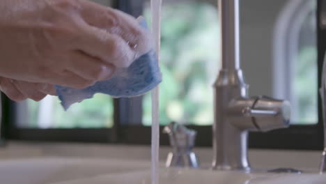 A-Caucasian-male-is-cleaning-a-French-whisk-in-a-home-kitchen