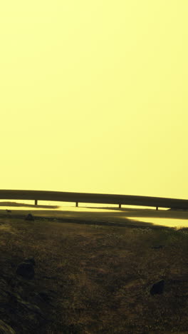 bridge over a calm body of water at sunrise