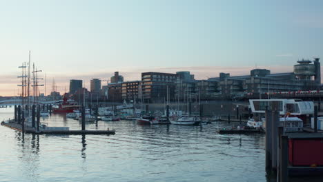 Low-aerial-dolly-view-of-anchored-boats-and-sailboats-in-Hamburg-harbor-at-sunset