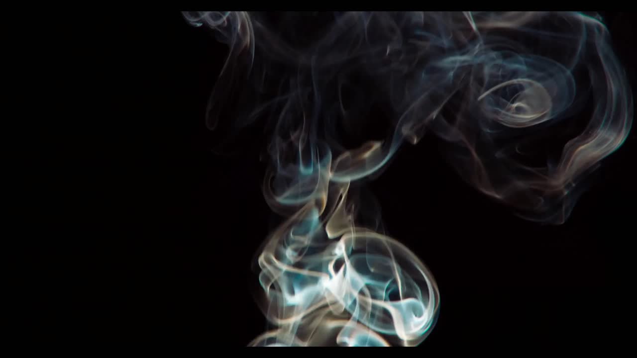 Fumo colorato che sale e vortica su sfondo nero