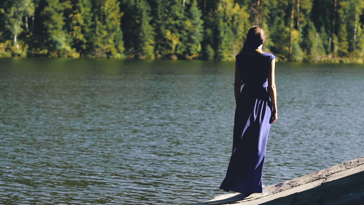 Woman in blue dress by the lake