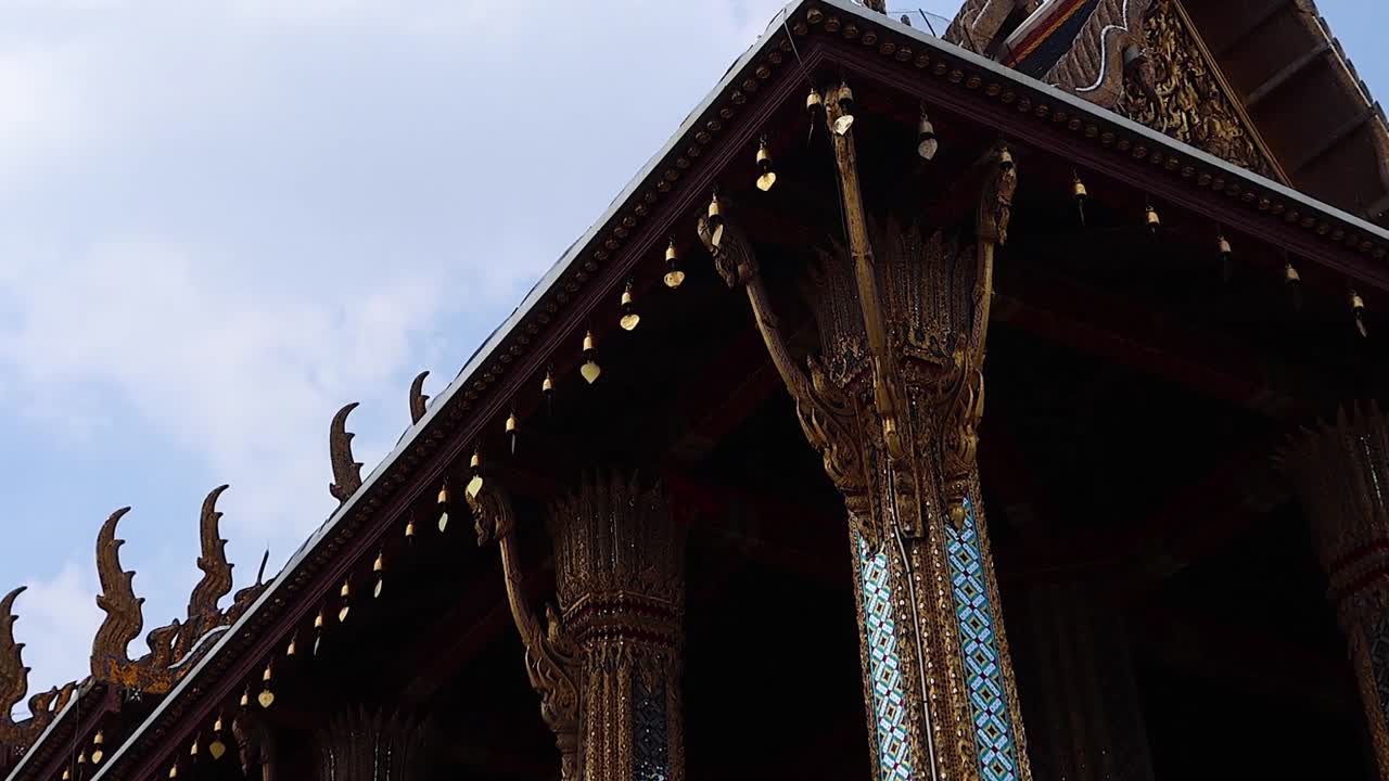 A detailed view of the temple's ornate facade and colorful columns, with visitors exploring the site.