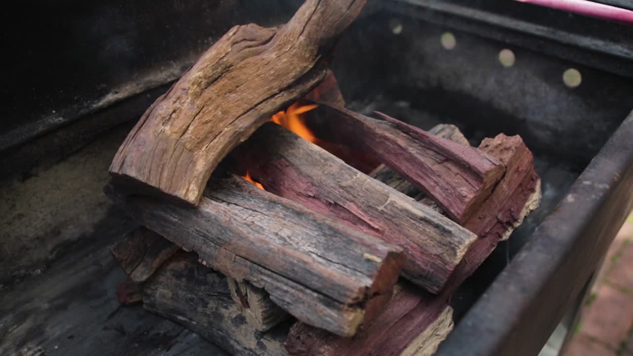 Wood being packed on an outdoor cooking fire