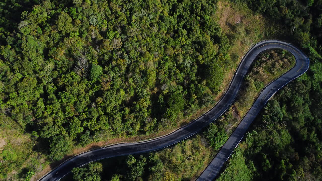 vista aérea de arriba hacia abajo de los vehículos que conducen por una sinuosa carretera de montaña a da lat, vietnam
