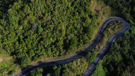 Vista-Aérea-De-Arriba-Hacia-Abajo-De-Los-Vehículos-Que-Conducen-Por-Una-Sinuosa-Carretera-De-Montaña-A-Da-Lat,-Vietnam