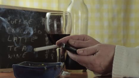 manos fumando cigarrillo y revisando el teléfono celular en un bar plano medio