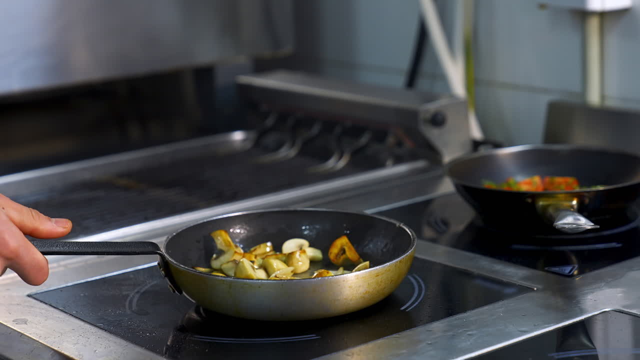 Chef cooks in pan. Chef in restaurant kitchen at stove with pan