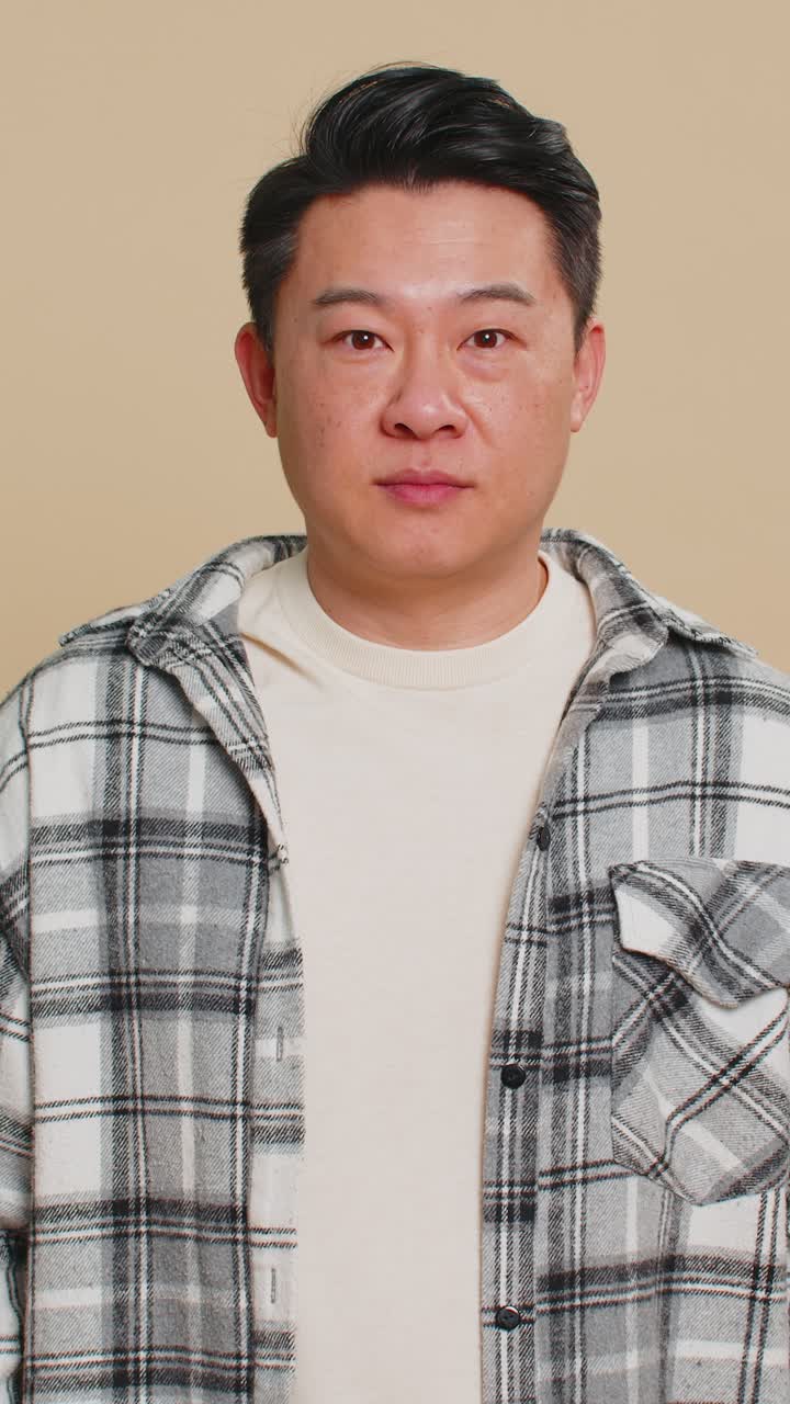 Asian man raises thumbs up agrees give positive reply recommends advertisement likes good idea