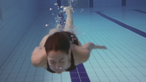 Underwater-Shot-Of-Woman-Swimming-In-Indoor-Pool