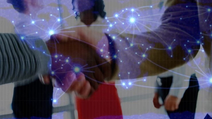 Glowing network of connections over mid section of two businessmen shaking hands at office