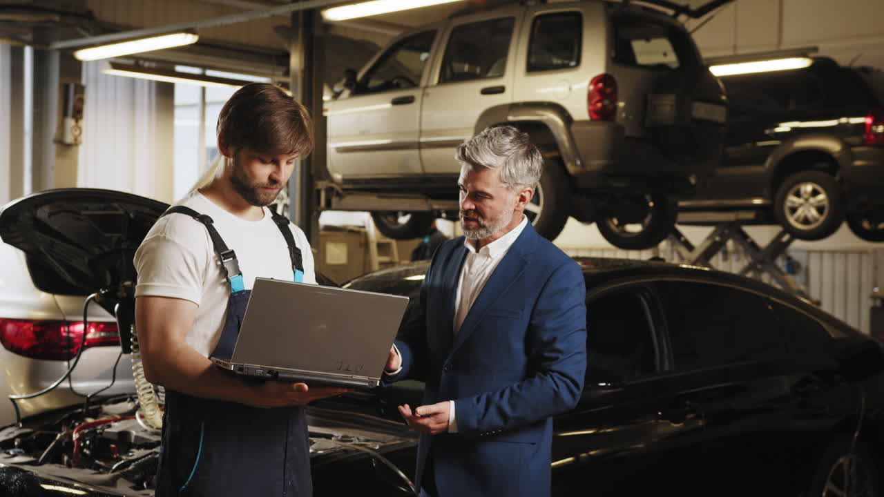 mecánico discutiendo reparación de automóviles con un hombre de negocios