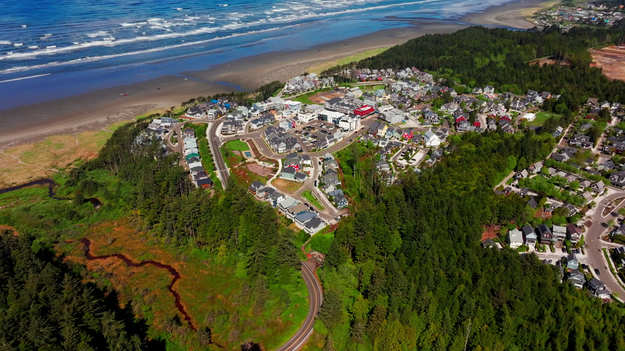 Aerial drone view of Seabrook on Washington’s Olympic Peninsula, capturing the coastal town, beach, oceanfront homes, and scenic Pacific Northwest shoreline from above.