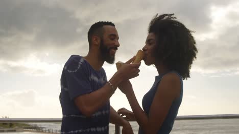 Couple-eating-ice-cream-cone-at-beach-4k