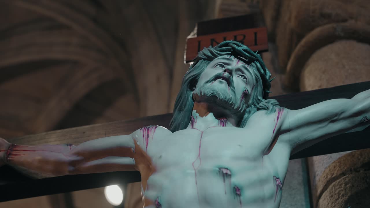 religious sculpture of crucified jesus in dramatic indoor lighting