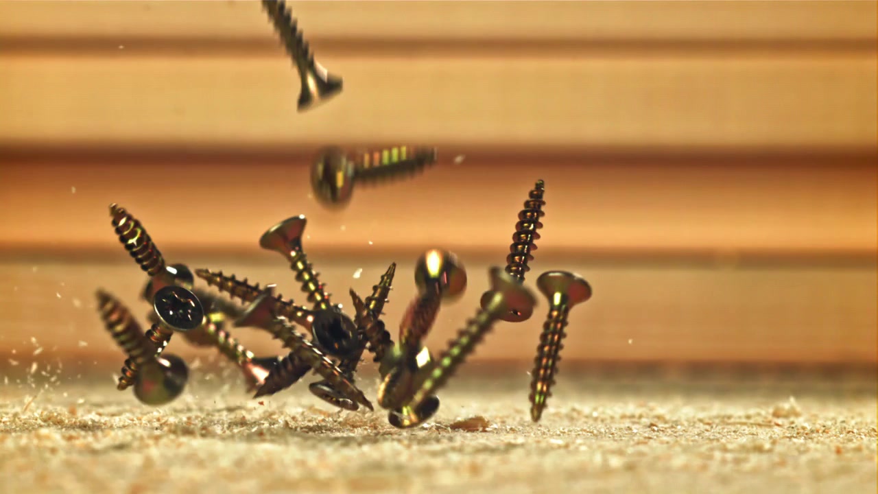 Golden Screws Falling in Slow Motion onto Sawdust and Wood