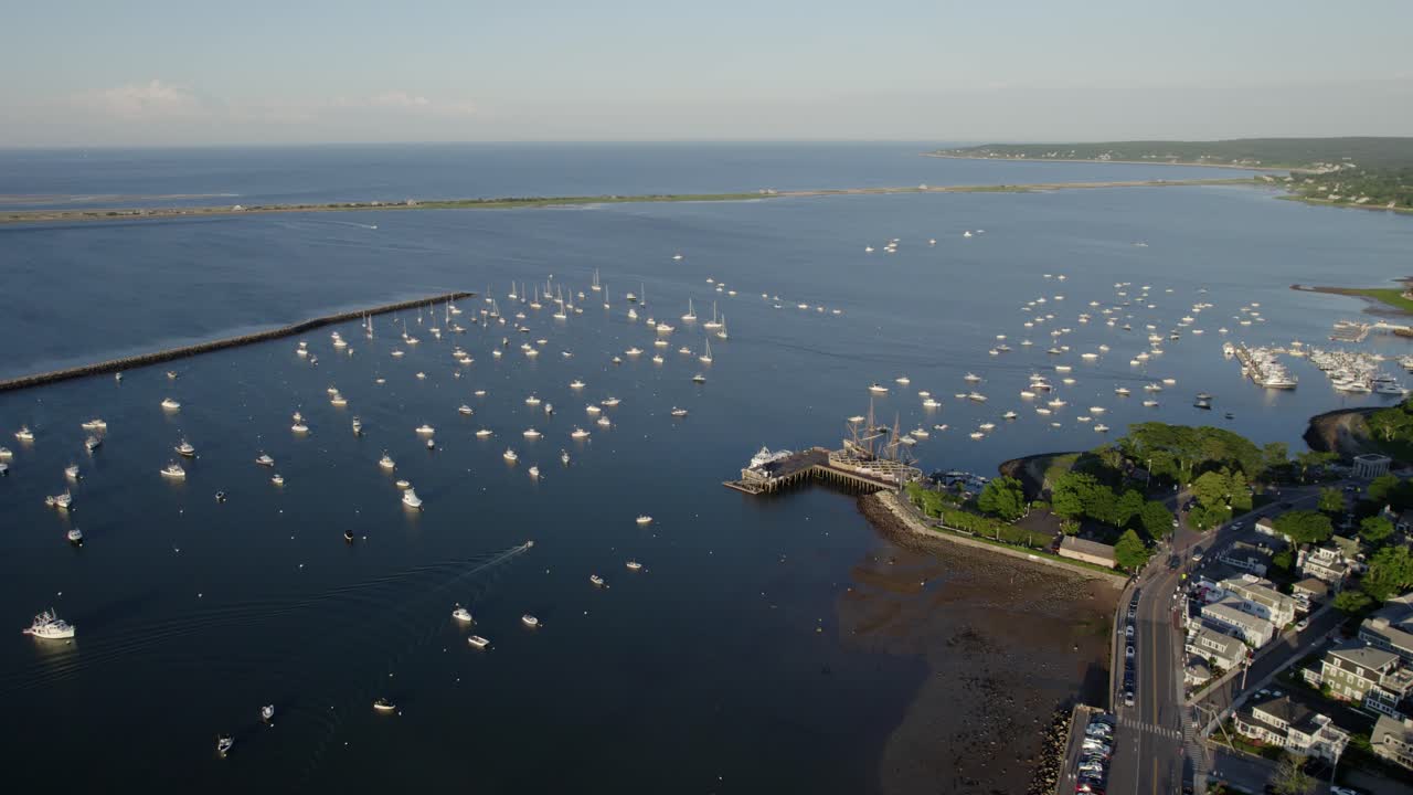 Aerial view ovelooking sunlit boats and the Mayflower II ship, summer evening on the coast of Plymouth, USA
