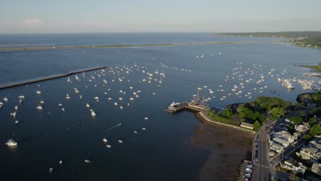 Vista-Aérea-Con-Vistas-A-Los-Barcos-Iluminados-Por-El-Sol-Y-Al-Barco-Mayflower-Ii,-Noche-De-Verano-En-La-Costa-De-Plymouth,-Estados-Unidos