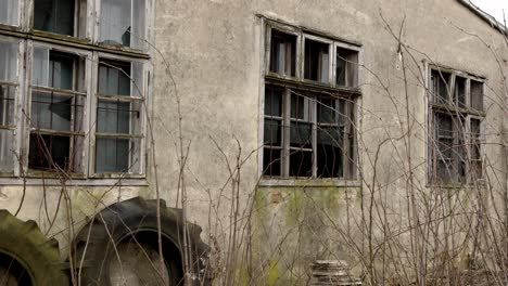 slow, thrilling arc shot of an abandoned building with cracked windows.