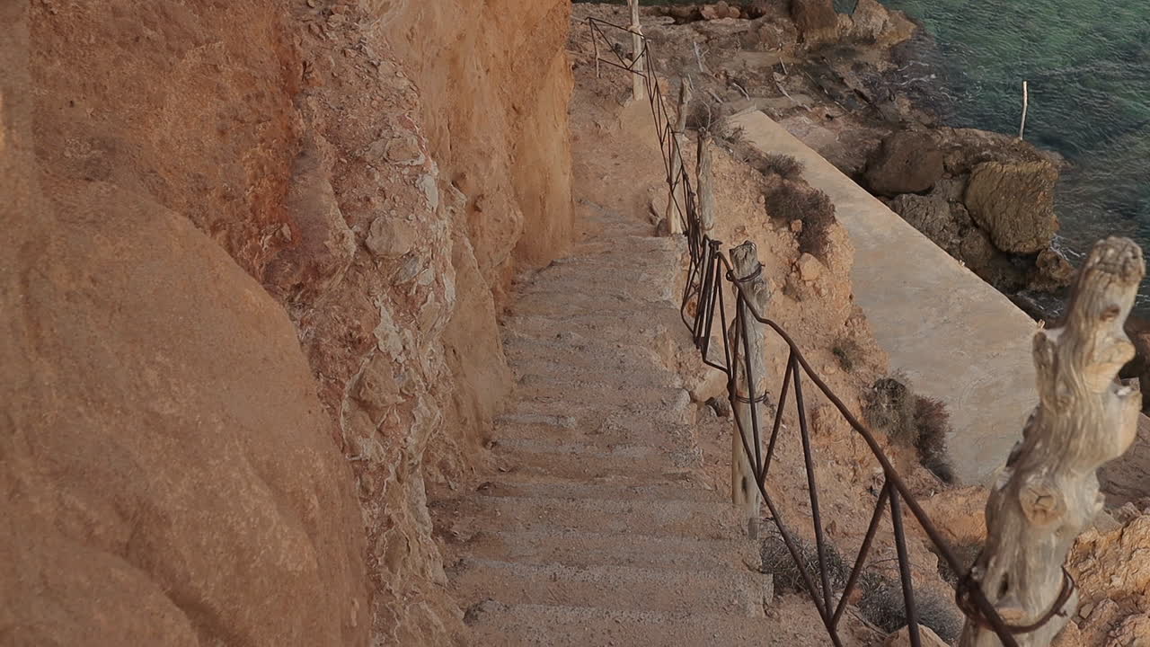 замедленная съемка спуска по скалистой лестнице на ибице