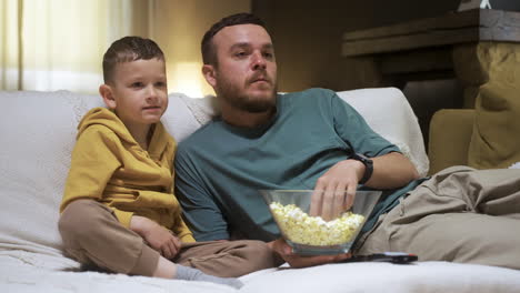 family sitting on the sofa and watching movie