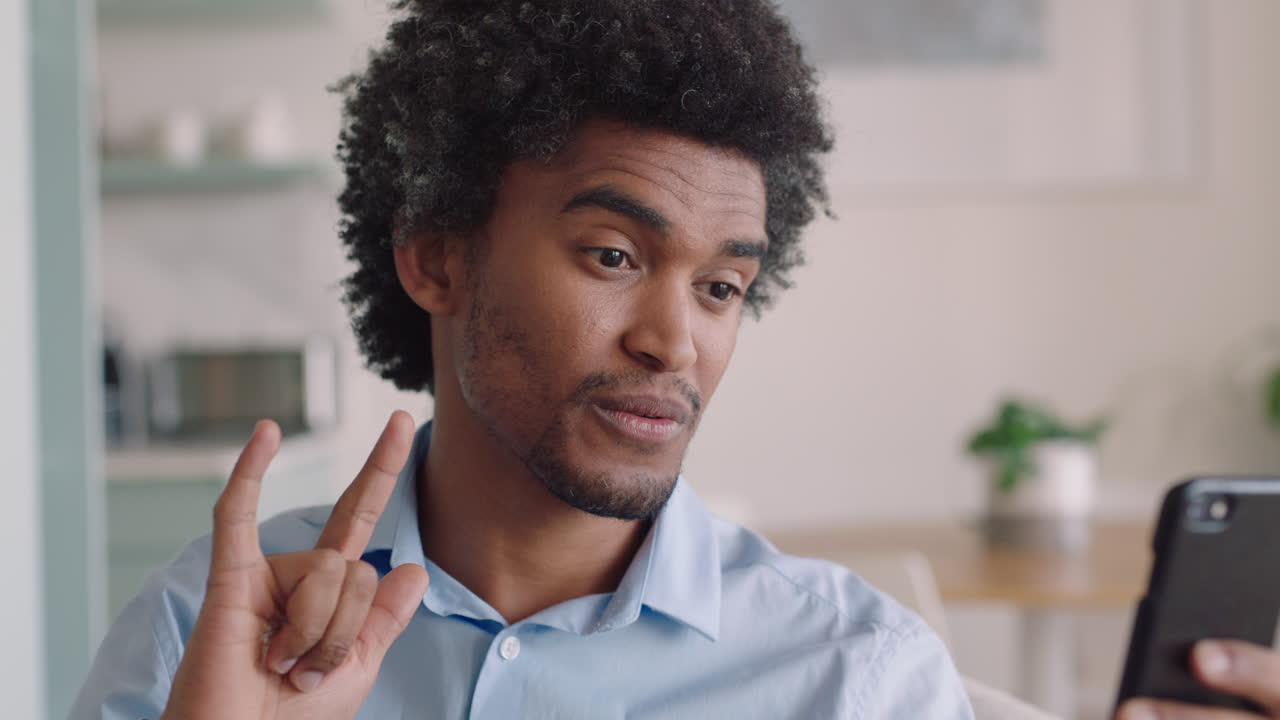 deaf man having video chat holding smartphone using sign language waving enjoying connection chatting on mobile phone