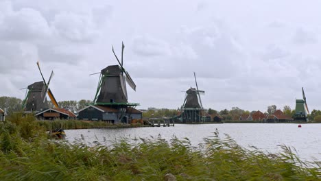 typical wooden dutch windmill rotating on a windy day in amsterdam, netherlands