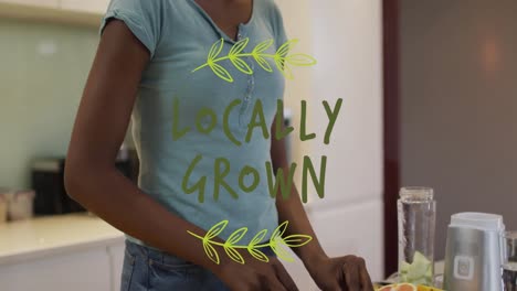 animation of locally grown text and leaves over happy african american woman cooking