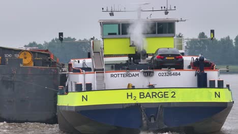 h2 barge 2 transporting a car on a river with exhaust steam