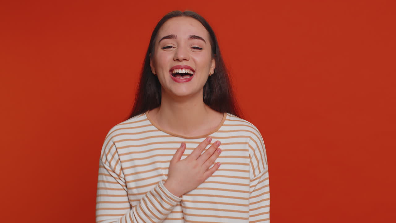 mujer bonita sonriente divertida señalando con el dedo a la cámara, riendo en voz alta anécdota chiste divertido