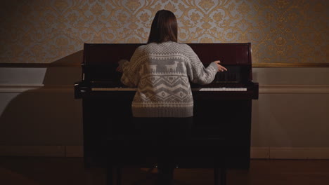 woman playing piano in elegant interior