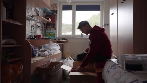 a young man is packing everything in his room ready for the move