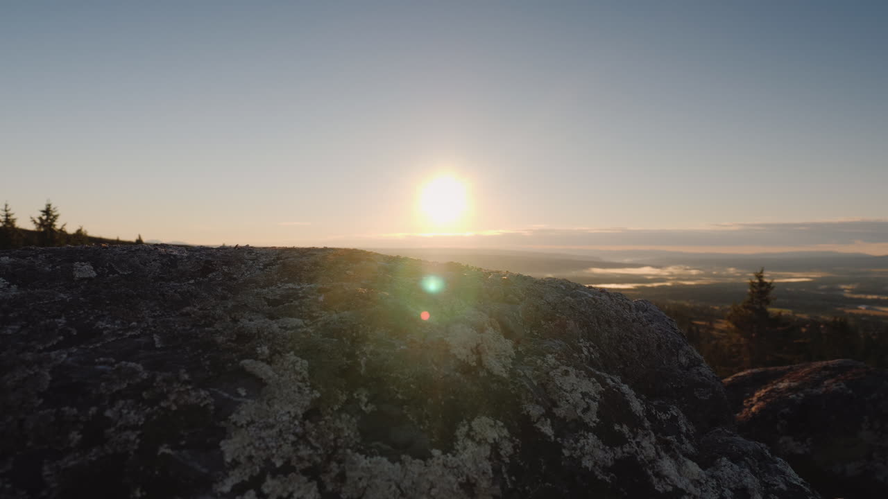 los pies del viajero en la cima del pico a través de ellos brilla el sol naciente y el hermoso paisaje